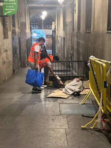 voluntarios ofrecen comida a un sintecho