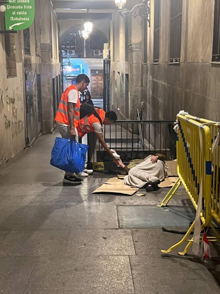 voluntarios ofrecen comida a un sintecho